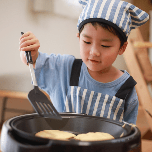 Criança cozinhando com a família